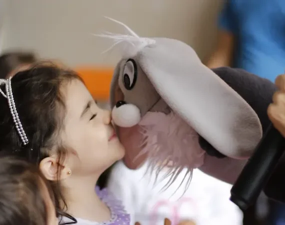 niña con personaje del show de títeres